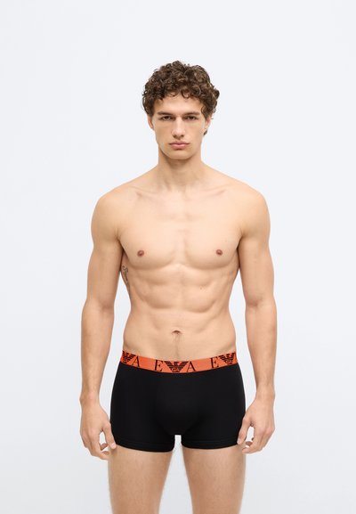 Boxer neri con vita con logo arancione. I boxer sono aderenti, realizzati in un materiale liscio ed elastico.