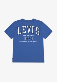 Modrá bavlněná trička s nápisem "LEVI'S" bílým písmem na zadní straně, s nápisy "THE ORIGINAL 1873" a "KVALITA NIKDY NEVYJDE Z MÓDY."