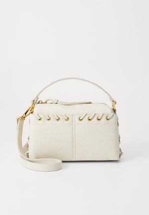 Sac à main en simili cuir blanc avec une fermeture éclair sur le dessus, une courte poignée et une bandoulière amovible avec des détails en métal doré. Détail de laçage sur le côté.