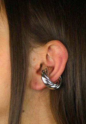 Zilveren oorring met een gedraaid spiraalontwerp, rustend in een doorboord oor. Gladde metalen textuur met reflecterend oppervlak.