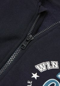 Marinefarbener Reißverschluss-Hoodie mit gestickten grafischen Elementen. Hat einen schwarzen Reißverschluss und einen weichen, strukturierten Stoff. Klassische Passform mit gerippten Details.