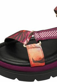 Schwarze Plateau-Sandalen mit bunten Blumenschlaufen und lila Veloursakzenten. Sie verfügen über goldene Hardware und eine gepolsterte Innensohle.