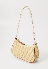 Tkaná slámová kabelka s křivkovým tvarem, béžové barvy, s hnědými koženými detaily a zlatým řetízkem. Zipové uzavření nahoře.