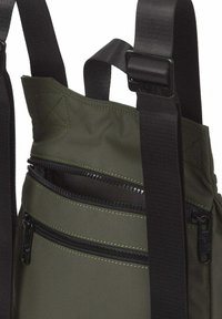 Mochila verde oliva con dos compartimentos con cremalleras y tirantes ajustables negros con hebillas.