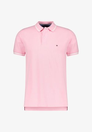 Polo homme rose clair à manches courtes avec bordure blanche sur le col et les manches, patte à deux boutons, et petit logo sur le côté gauche de la poitrine.