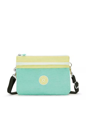 Una borsa a tracolla verde menta con strisce gialle e bianche, un logo circolare e una tracolla nera rimovibile. Realizzata in tessuto resistente.