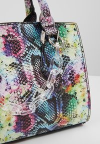 Kolorowa, teksturowana torebka z motywem skóry węża. Wykonana z materiału syntetycznego, z przezroczystymi okuciami i żywym, wielokolorowym wzorem.