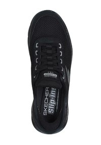 Zapato negro de Skechers tipo slip-on con parte superior de malla, cuello acolchado y plantilla de espuma con memoria. Cuenta con seis ojales y una suela de goma lisa.