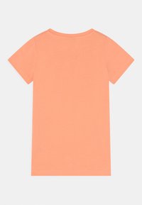 T-shirt de manga curta em coral claro, feito de algodão macio. Apresenta um decote redondo e um design simples, sem padrões ou detalhes.