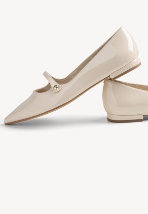 Chaussure plate avec un dessus en cuir verni beige brillant, un bout pointu, un petit talon et une sangle avec un bouton décoratif sur le côté.