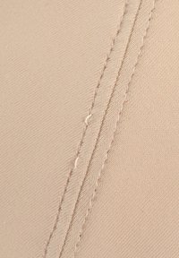 Beige fabric with a textured surface, displaying visible stitching along the edges. The material appears smooth with a slight sheen.