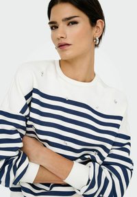 Vit och marinrandig sweatshirt med silverdetaljer, rund halsringning och ribbade ärmslut. Mjuk textur med avslappnade ärmar.