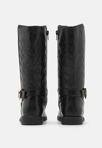 Bottes noires jusqu'aux genoux avec un motif cœur texturé, finition lisse, zip sur le côté et un accent boucle sur la sangle de la cheville.