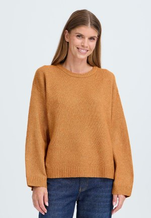Pull en tricot couleur ambre avec un col rond, des épaules dénudées et un ourlet côtelé. Le tissu a une finition texturée, légèrement scintillante.