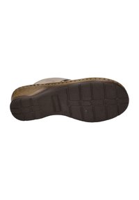 Sandal sole with textured rubber, featuring a brown color and a patterned surface for enhanced grip, showcasing ridges and grooves.