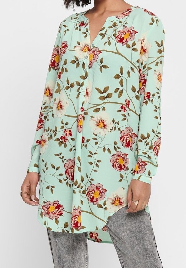 Tunique fleurie bleu clair à manches longues, ornée de fleurs rouges et jaunes, avec un col en V et une fermeture par boutons. Texture de tissu lisse.