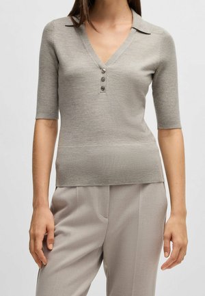 Top grigio a maniche corte in maglia con scollo a V, apertura con cinque bottoni e trama a coste. Presenta un colletto sottile e una vita aderente.