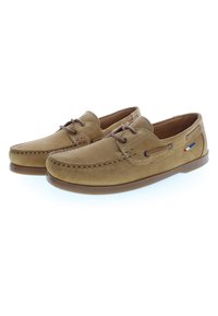 Zapatos de ante beige con cordones marrones, detalle de costura y una suela de goma en contraste. Presenta ojales de metal y una pequeña etiqueta multicolor.