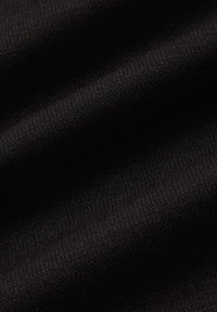 Czarna tkanina elastyczna o gładkiej teksturze, z delikatnymi wzorami fal i cienkim splotem, idealna do wszechstronnych zastosowań odzieżowych.