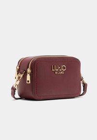 Lille rektangulære maroon læder crossover taske med gyldne lynlåse, spænder og "LIU·JO MILANO" logo på forsiden.