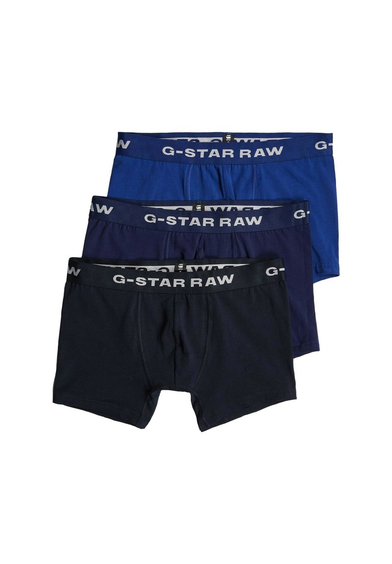 Pak trijeh G-Star RAW bokserskih hlačic v mornarsko modri, temno modri in črni barvi. Značilnosti vključujejo pas z logotipom, bombažni material in gladko teksturo.