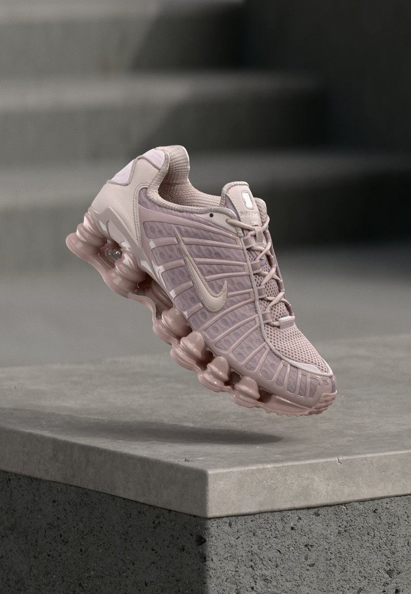 Pantofi Nike Air Max în roz deschis, cu partea superioară din plasă, limbă căptușită și talpă groasă, transparentă, cu un design în valuri.