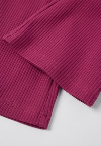 Kohoku kangasta syvässä magentassa väriä, jossa on sileät reunat. Ominaisuuksiin kuuluu hieman kaarevat helmat ja pehmeä tekstuuri, joka korostaa neulekuosisuunnittelua.