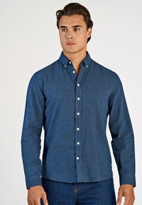 Camicia azzurra con bottoni, realizzata in tessuto strutturato. Presenta un colletto classico, maniche lunghe e bottoni bianchi sul davanti. Design a tinta unita.