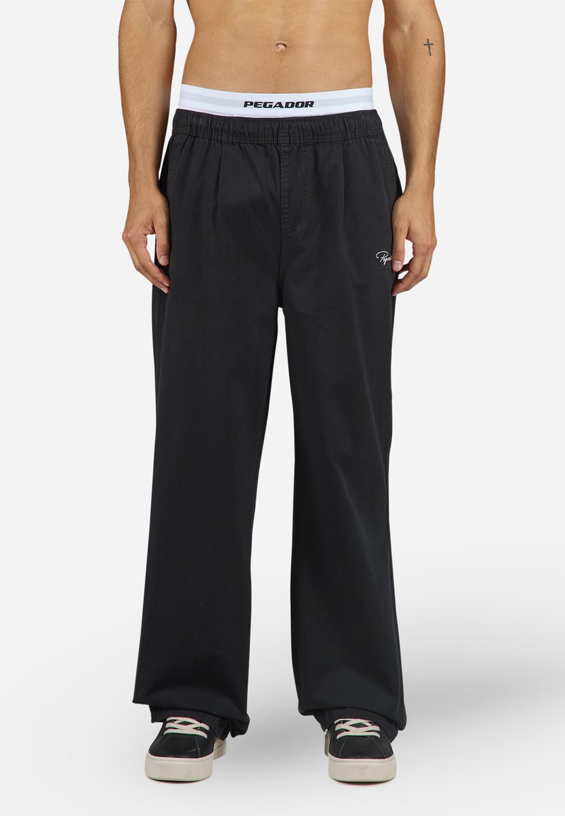 Pantalones de pierna ancha negros con cintura elástica y logotipo blanco de PEGA DOR, confeccionados en tejido suave, ideales para un look casual.