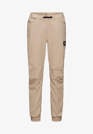 Pantalons légers beiges au design fuselé, avec des poignets élastiques, des poches latérales et un patch logo sur la cuisse gauche. Texture lisse.