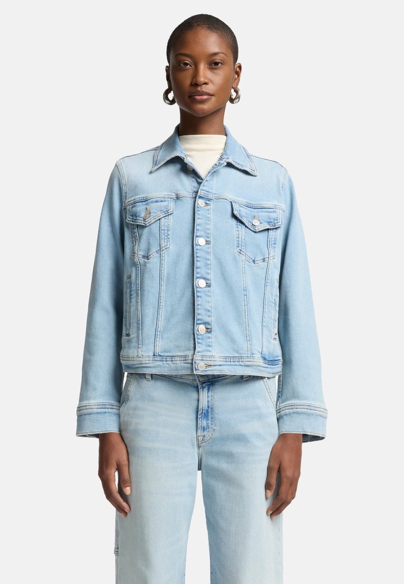 Ljusblå denimjacka med kortad design, två bröstfickor, vita sömmar och silverfärgade knappar. Mjuk textur och avslappnad passform.