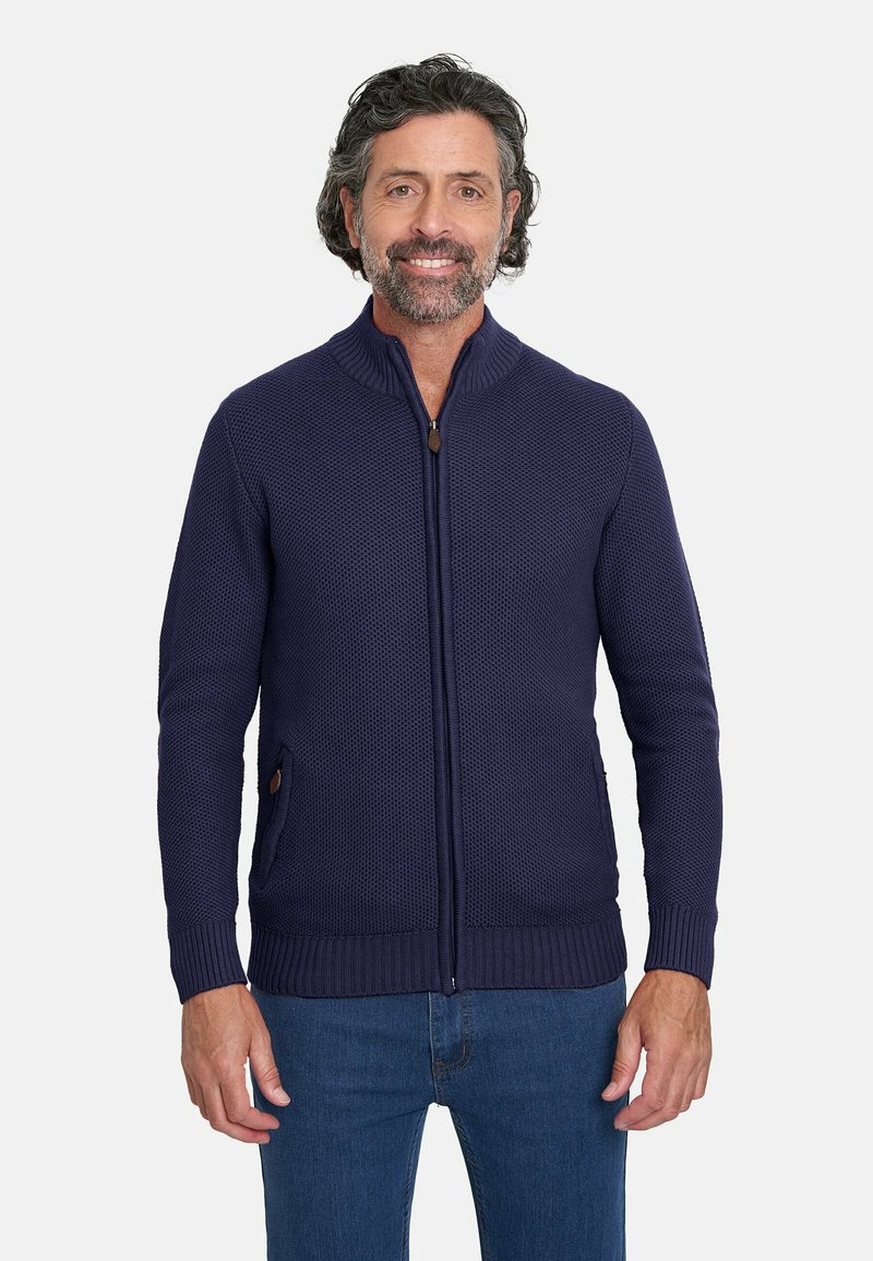 Cárdigan de punto azul marino con cremallera, que presenta puños y dobladillo de canalé, y bolsillos laterales con detalles de cuero.