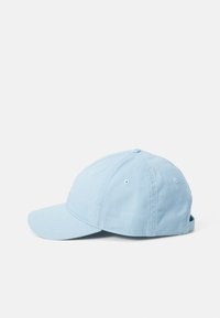 Casquette en coton bleu clair avec une visière courbée, six trous de ventilation et une sangle réglable à l'arrière. Design simple et dépouillé.