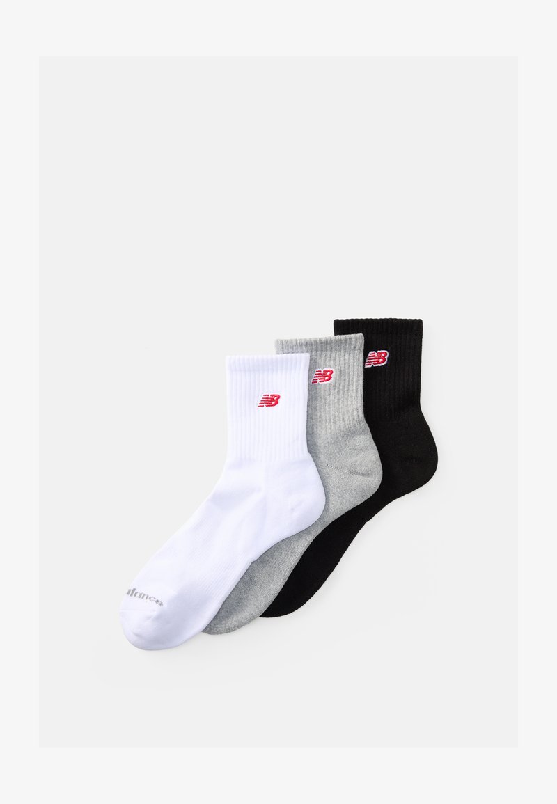 Tri páry ponožiek do členkov v bielej, sivej a čiernej farbe, s jemnou textúrou a malým červeným logom New Balance na každej ponožke.