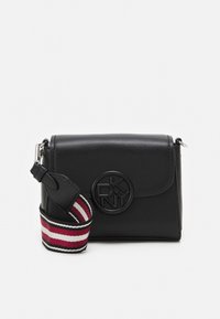 Borsa a tracolla in pelle nera DKNY con chiusura a pattina e logo rotondo, dotata di una tracolla in tessuto staccabile a righe rosse, bianche e nere.