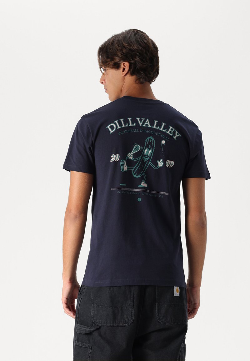Navyblaues Baumwoll-T-Shirt mit einem Pickle-Charakter-Graphic, mit dem Text "DILL VALLEY PICKLEBALL & RACQUET HALL" und dem Gründungsdatum auf der Rückseite.