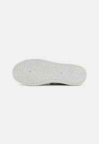 White shoe sole featuring floral pattern details and the brand name "BOBS." Smooth texture with rounded edges and a slightly curved shape.