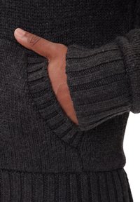 Dunkelgrauer Strickpullover mit gerippten Bündchen und Saum, seitlicher Tasche sichtbar, die ein strukturiertes und gemütliches Design hervorhebt.