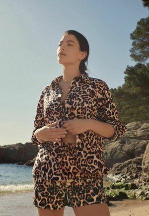 Leopardų rašto marškiniai ir šortai, su apykakle, mygtukų uždarymu bei lengvu audiniu, aptempto silueto ir trumpomis rankovėmis.