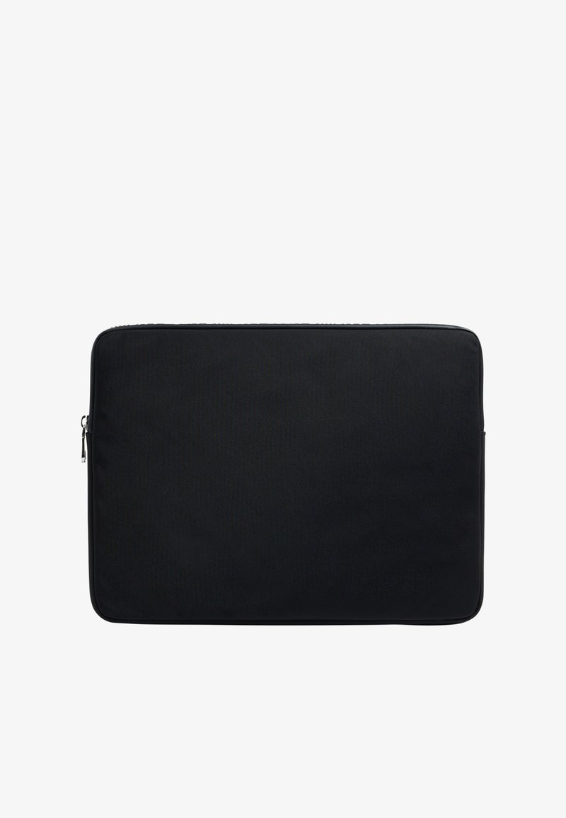 Funda negra para portátil con un exterior de tela suave, forma rectangular, cierre de cremallera y sin logotipos ni patrones visibles. Diseño minimalista.