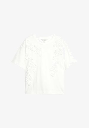 Bílý krátký rukáv tričko s texturovanou květinovou aplikací na jedné straně. Pohodlný bavlněný materiál s volným střihem.