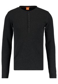 Svart långärmad henley-tröja i en strukturerad tyg med rundad halsringning och tre knappar i placket. Inga mönster eller accenter.