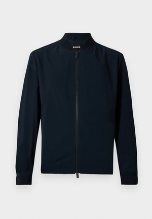 Veste de bombardier marine en tissu lisse, avec une fermeture éclair sur le devant, un col montant et des poignets côtelés, au design minimaliste.