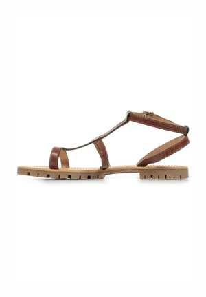 Sandalo in pelle marrone con più cinturini, suola piatta e una leggera texture. Presenta una chiusura con fibbia e un battistrada robusto sulla suola.