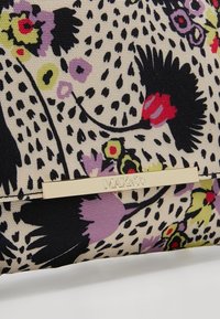 Pochette à motif floral sur fond crème, présentant des motifs noirs, violets, rouges et verts. Détail en métal doré avec logo embossé.