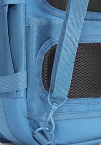 Modrá látková batohová sekce s několika popruhy, síťovými detaily a plastovou sponou. Texturovaný materiál s vyztuženým šitím.