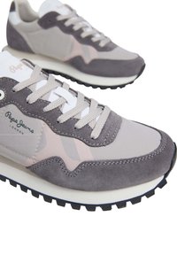 Gray and pink sneaker featuring suede and fabric materials, round toe, textured sole, and branded detail on the side. Lace-up closure.