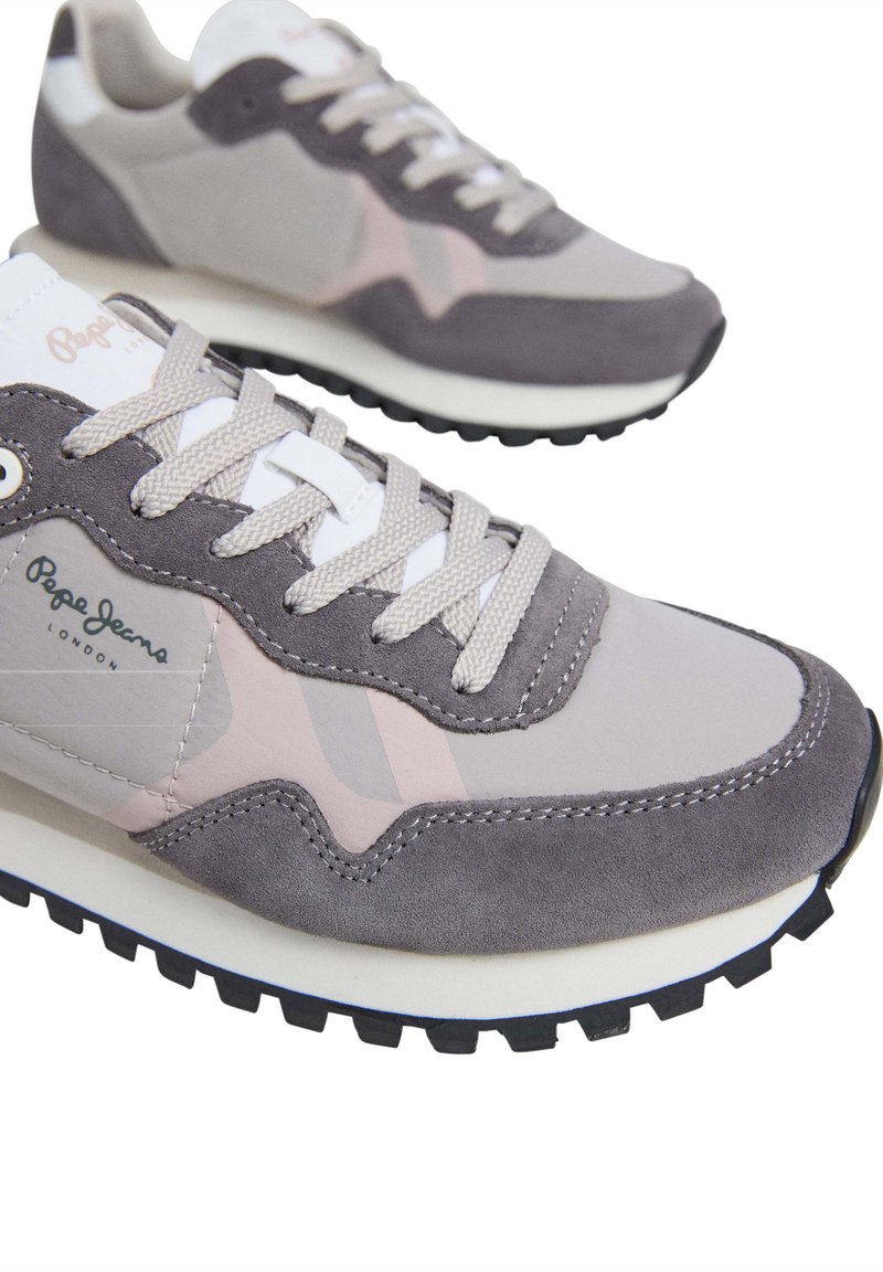 Sneaker grigio e rosa in materiali scamosciati e tessili, punta tonda, suola texturizzata e dettaglio del marchio sul lato. Chiusura con lacci.