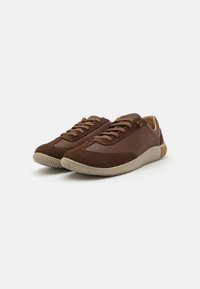 Braune Sneaker aus Wildleder und Leder, mit einer strukturierten Oberseite, Gummisohle und Schnürdesign. Niedriges Profil mit dezenten Nähten.