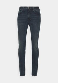 Jeans de mezclilla oscura con un ajuste slim, diseño de cinco bolsillos, cintura de media altura y un ligero desgastado. Cuentan con un cierre de botón y cremallera.
